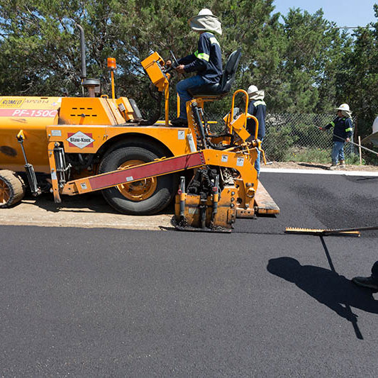 crew member setting asphalt