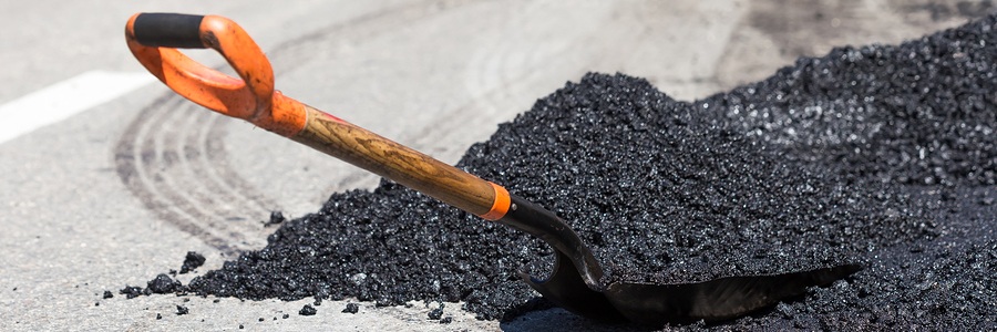 shovel in a pile of asphalt ready for repairs